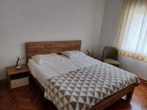 a bedroom with a large bed and a chair at Apartments Vili in Umag