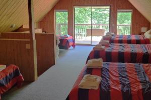 a attic room with three beds and a staircase at Flyers' Landing in Jacksboro