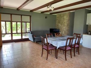 - une salle à manger avec une table, des chaises et un canapé dans l'établissement Agroturystyka Nad Czarnym, à Giby