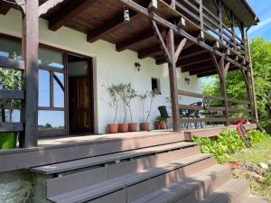 a house with a wooden porch with plants on it at Agroturystyka Nad Czarnym in Giby