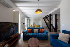 uma sala de estar com um sofá azul e uma televisão em VIlla São Lourenço by AcasaDasCasas em Ericeira