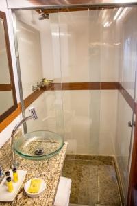 uma casa de banho com uma cabina de duche em vidro e um lavatório. em MV Desafio em Manaus
