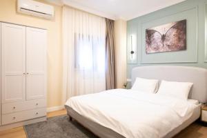 um quarto com uma cama branca e uma janela em Green sophia suite em Istambul
