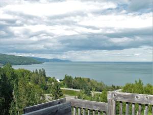 a view of the water from a wooden fence at Studios d'hébergement du Domaine in Saint-Irénée