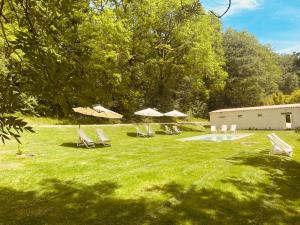 a group of chairs and umbrellas in a yard at Gîte de Fompesquiere in Frespech