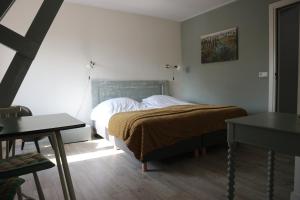 a bedroom with a bed and a window and a table at B&B - Pension Het Oude Dorp in Katwijk