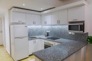 a kitchen with white cabinets and a counter top at Beautiful Apartment in Egyptian Experience Resort in Sharm El Sheikh +5 photos