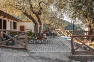 a patio with a table and chairs under a tree at Case Vacanze Dalisa Castagno Con Parcheggio in Tramonti