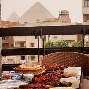 un plato de comida en una mesa en un balcón en Zahira Pyramids View en El Cairo