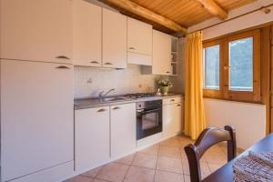 a kitchen with white cabinets and a sink and a table at Case Vacanze Dalisa Castagno Con Parcheggio in Tramonti
