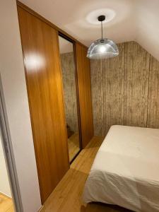 ein kleines Schlafzimmer mit einem Bett und einem Spiegel in der Unterkunft Chambre proche de la citadelle in Montmédy