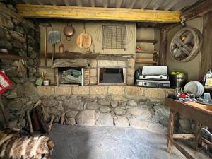 eine Küche mit einem Steinkamin und einem Herd in der Unterkunft Petit chalet en pleine nature avec accès rivière in Venaco