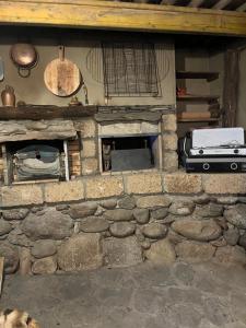 einen Steinkamin in einem Zimmer mit einer Steinmauer in der Unterkunft Petit chalet en pleine nature avec accès rivière in Venaco