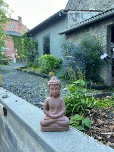 posąg buddy siedzącej na ścianie w obiekcie 2pas2meuse w mieście Waulsort