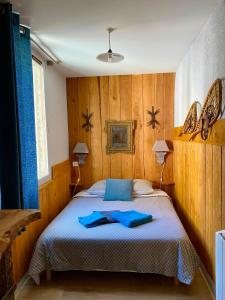 a bedroom with a bed with blue towels on it at Le Passage in Ax-les-Thermes