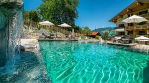 a swimming pool with a waterfall in a resort at Alpen-Chalet-Pankraz in Fügenberg