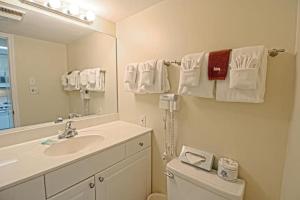 a bathroom with a sink and a toilet and a mirror at Pepper Tree by the Sea in Myrtle Beach