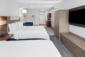 a hotel room with two beds and a flat screen tv at Holiday Inn Express & Suites Carmel North – Westfield, an IHG Hotel in Carmel