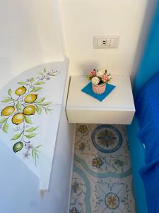 einen kleinen weißen Tisch mit einer Schüssel Blumen drauf in der Unterkunft La Piccola Suite in Anacapri