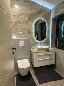a bathroom with a sink and a toilet and a mirror at Mirabilis Apartments in Međugorje +71 photos