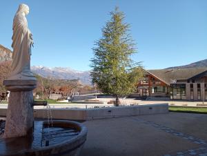 a fountain with a statue in front of a building at Noyers du Soleil, Chambre d'hôte avec petit déjeuner à proximité de Gap in La Bâtie-Vieille