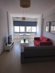 Una sala de estar con un sofá rojo y una mesa. en The Heart of the City, en Limassol