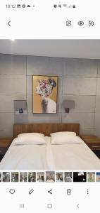 a bedroom with a bed with a painting on the wall at Holiday House in Krynica Morska