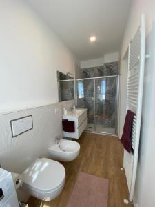 un bagno bianco con un water e un lavandino di Lellolocations - Casa Osina a San Costanzo