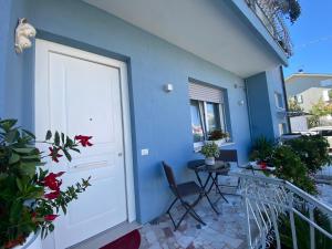 una casa blu con una porta bianca e un tavolo su un balcone di Lellolocations - Casa Osina a San Costanzo