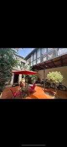 une terrasse avec une table, des chaises et un parasol dans l'établissement Villa Bass, à Bab el Oued