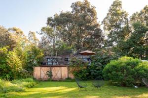 Godínez的住宿－Casita Panadería, Cozy House in San Simón，两把椅子放在院子内,房子的背景