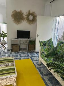 ein Wohnzimmer mit einem Sofa und einem TV in der Unterkunft Tabasamu Gardens in Diani Beach