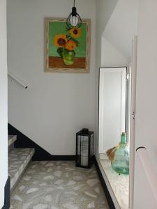 a hallway with a painting and a vase on a table at Casa Pancha in Ribadeo