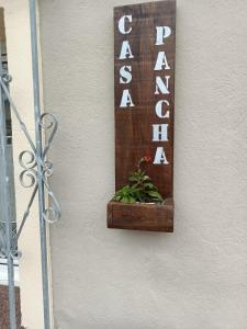 a sign on a wall with a plant in a wooden box at Casa Pancha in Ribadeo
