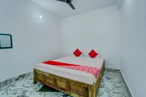 um quarto com uma cama com almofadas vermelhas em OYO Flagship Your Room & Guest House em Patna