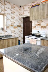 uma cozinha com um balcão de granito num quarto em The Hidden Gem Wuye em Abuja