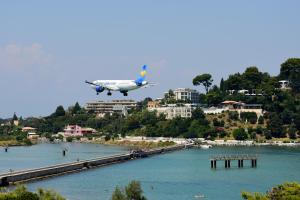 samolot leci nisko nad wodą w obiekcie Ionian Luxury Apartments w mieście Perama