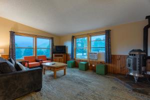 a living room with a couch and a stove and windows at Discovery Lodge in Estes Park