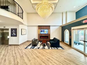 a lobby with two chairs and a chandelier at Comfort Suites East Brunswick - South River in East Brunswick