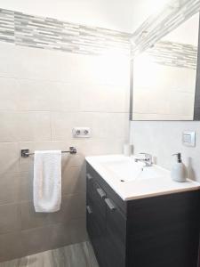 Baño blanco con lavabo y espejo en Casa Los Lajares, en Tinajo