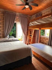 1 dormitorio con 2 camas y ventilador de techo en Cabaña Campestre Privada Tinita´s Chalet en Taulabé