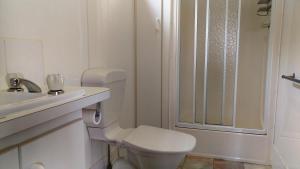 a white bathroom with a toilet and a sink at Prom Central Caravan Park in Foster