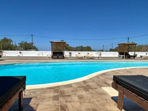 een groot zwembad met blauw water bij Delight Apartments suites in Stelida
