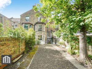 ein altes Backsteinhaus mit einem Baum davor in der Unterkunft Hackney Guest Rooms in London