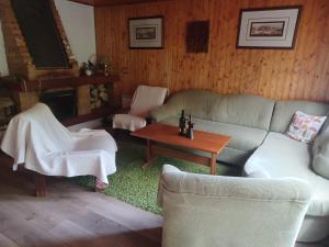 a living room with a couch and chairs and a table at Chata Ružín-Rolova Huta in Margecany