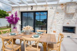 a wooden table and chairs on a patio with a fireplace at LUZ BLANCA in Agios Leon