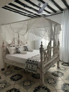 a bedroom with a bed with a canopy at Tabasamu Gardens in Diani Beach