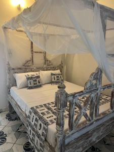 ein Schlafzimmer mit einem Himmelbett in der Unterkunft Tabasamu Gardens in Diani Beach