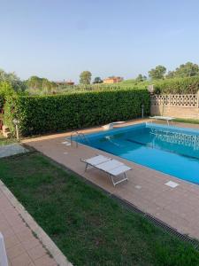 een zwembad met een bank in een tuin bij Villa Fiore in Nettuno