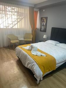um quarto com uma cama grande e um cobertor amarelo em BY KARAM OTELCİLİK em Istambul